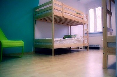 Pogled na dorm s krevetima na kat i visokim prozorom